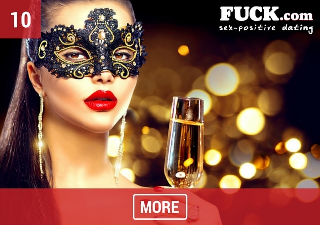 Sexy woman in a beautiful mask drinking champagne